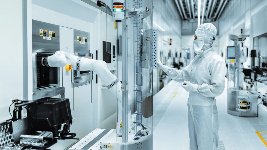 Robot arm and engineer inside a semiconductor cleanroom